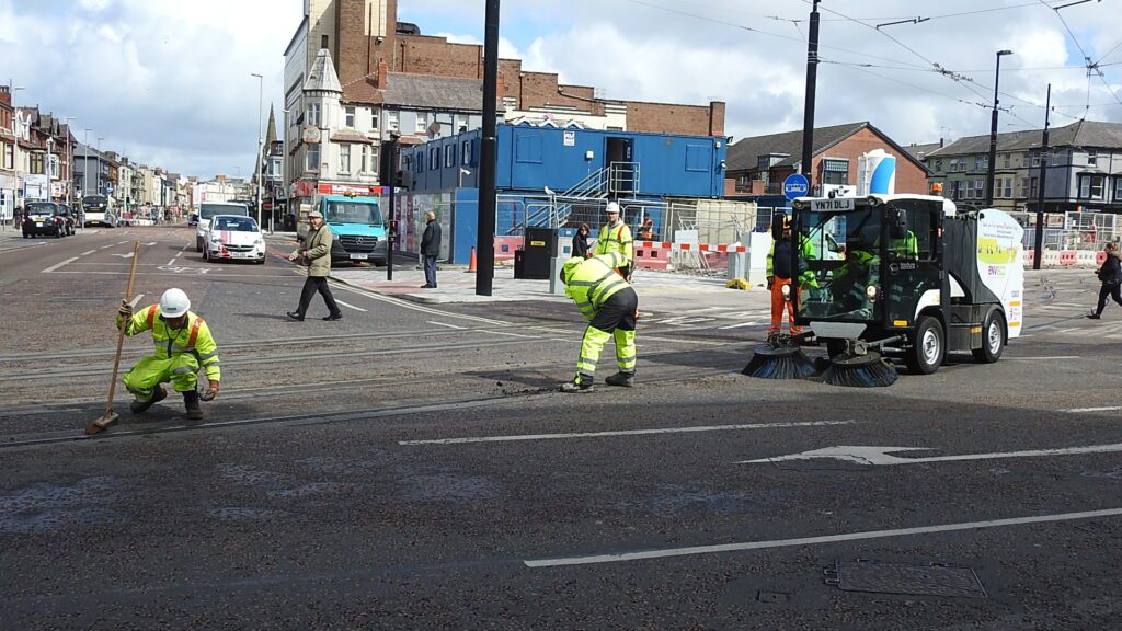 Prior to the test run, a gang were out clearing the tracks with the aid of a pavement sweeper. Photo: Barrie C Woods